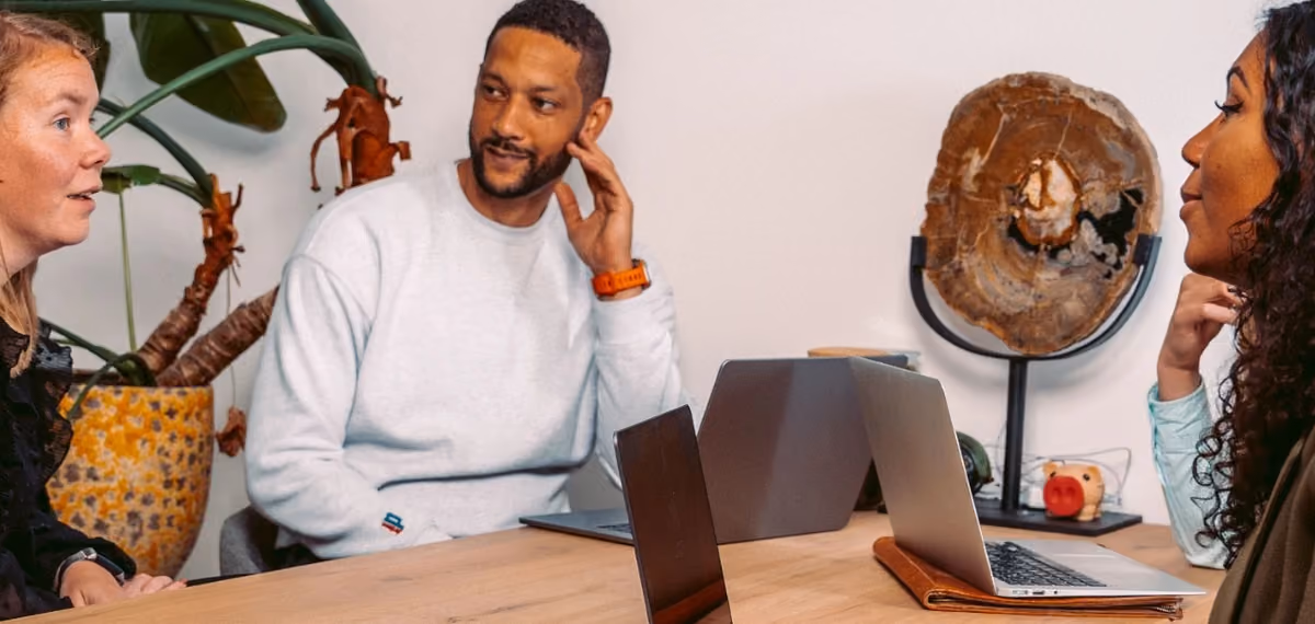 Drie collega's van Intego Zorg in overleg met laptops aan tafel
